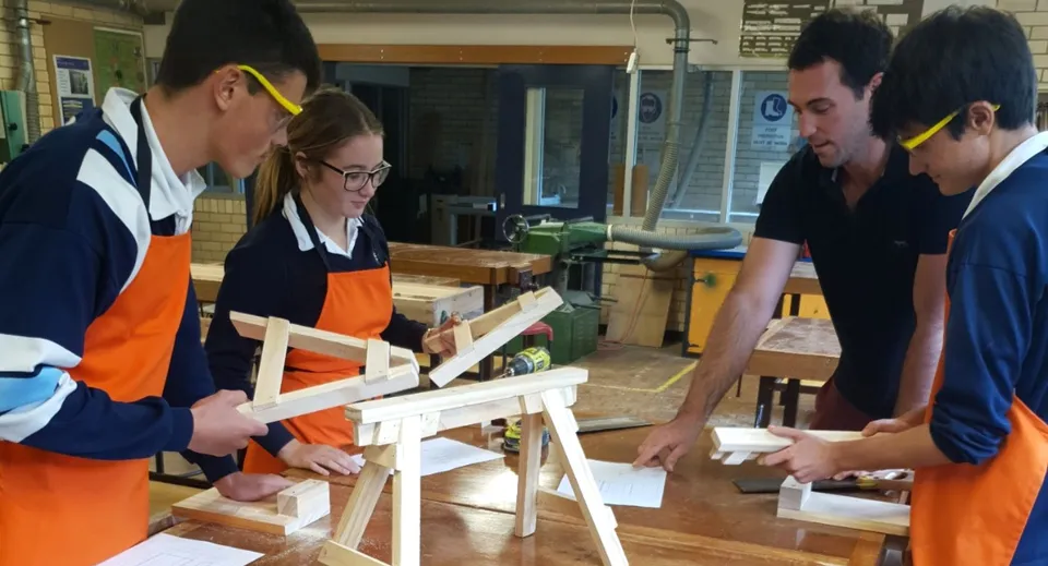 Studenti della Kelvin High School lavorano insieme a un progetto in legno nel laboratorio.