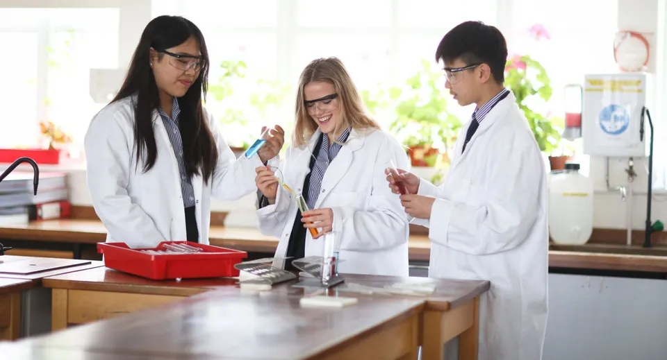Tre studenti della Sidcot School lavorano insieme in un laboratorio con strumenti scientifici.