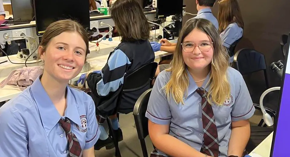 Un gruppo di studenti in divisa scolastica si trova in un'aula della Mitchelton State High School.