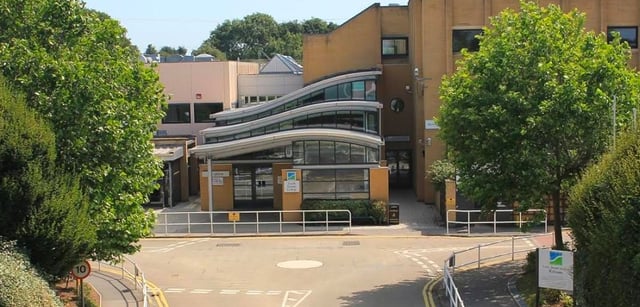 L'edificio moderno del South Downs College è circondato da alberi verdi ed è raggiungibile tramite un viale pavimentato.