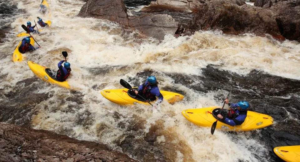 Studenti della Ballingarry Presentation School fanno rafting su un fiume spumeggiante in un ambiente roccioso.