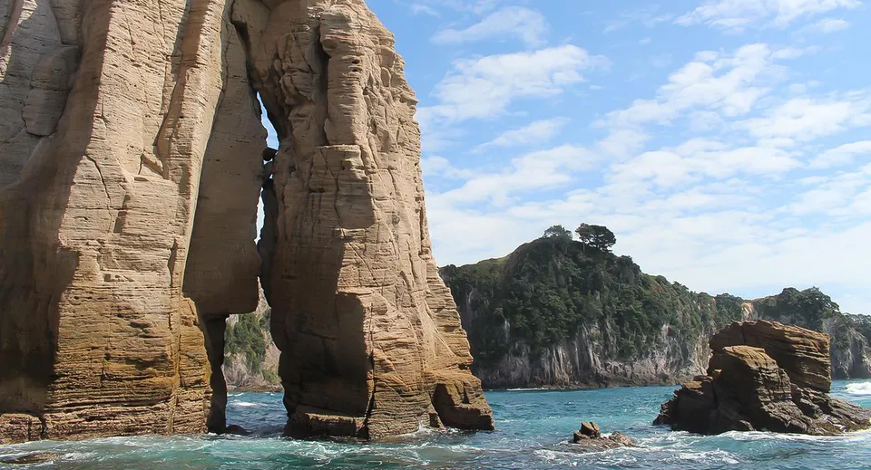 Formazioni rocciose emergono da acque turchesi, circondate da vegetazione e montagne, vicino all'Upper Hutt College.