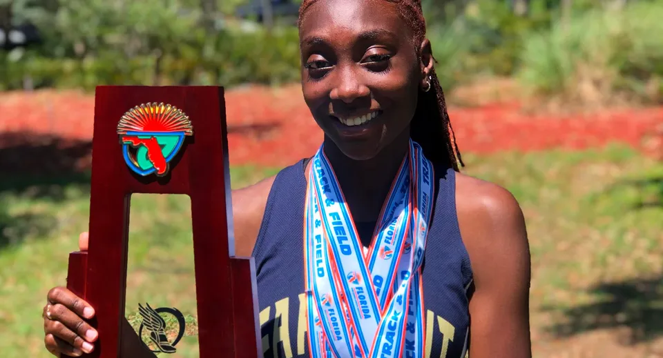 Una persona in abito tradizionale africano si trova nel verde all'interno del campus della Admiral Farragut Academy.