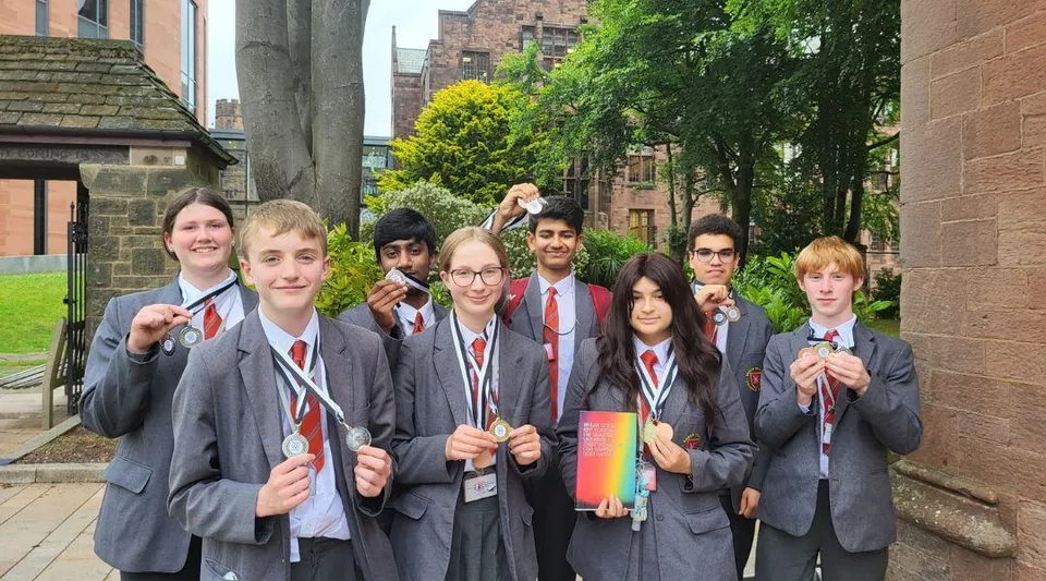 Un gruppo di studenti in divisa scolastica sta davanti a un edificio storico nel campus della North Halifax Grammar School.