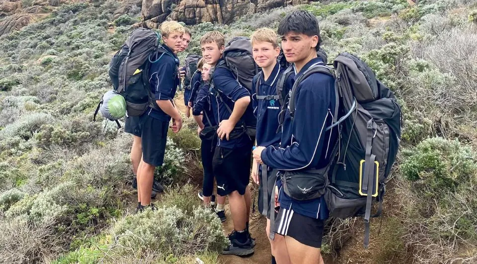Studenti della Kalamunda Senior High School si trovano su un sentiero di montagna roccioso circondato da una fitta vegetazione.