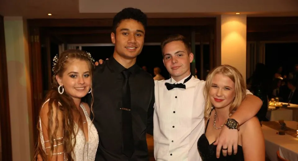 Un gruppo di quattro persone in abito formale posa insieme a un evento della Wellington Point State High School.