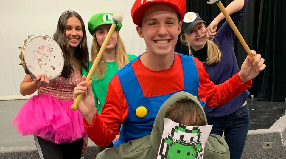 Un gruppo di studenti della Thomas A. Blakelock High School in costumi colorati durante una rappresentazione ludica.