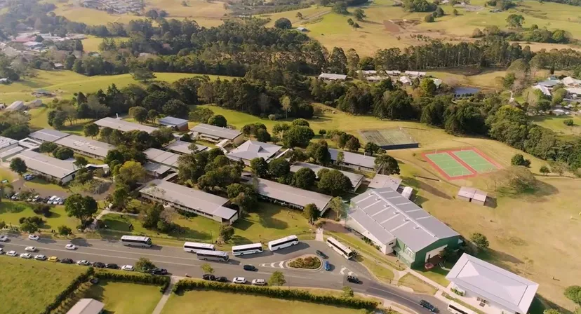 La foto aerea mostra l'impianto sportivo e gli edifici della Maleny State High School in un ambiente rurale con colline e foreste.