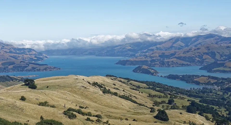 Un lago pittoresco con colline e montagne sullo sfondo, fotografato nei pressi della Hillmorton High School.