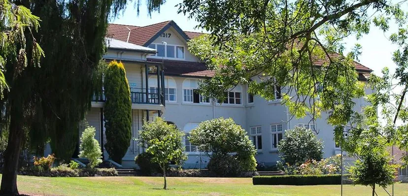 L'edificio a più piani del Solway College è circondato da alberi, cespugli e un prato ben curato.