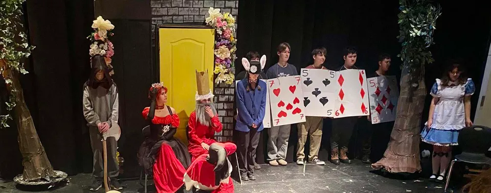 Studenti della Cedar Community Secondary School sul palco con costumi teatrali.