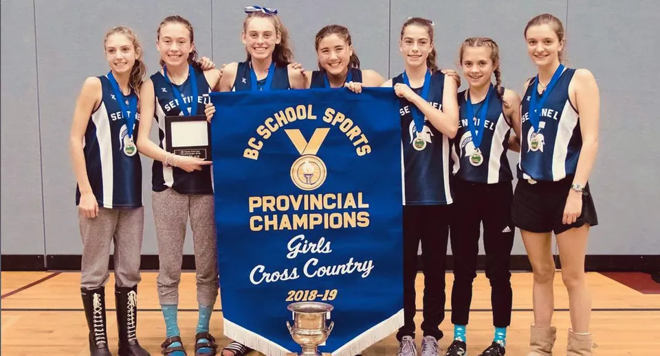 Le studentesse della Sentinel Secondary School mostrano con orgoglio uno striscione come campionesse provinciali di corsa campestre femminile della stagione 2018-19.