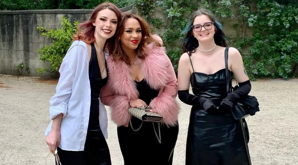 Tre studentesse della Bath Academy mettono in posa insieme in un'area verde all'aperto.