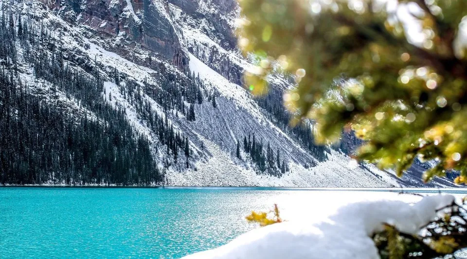 Un lago turchese davanti a montagne innevate e pini nei pressi della Glengarry District High School.
