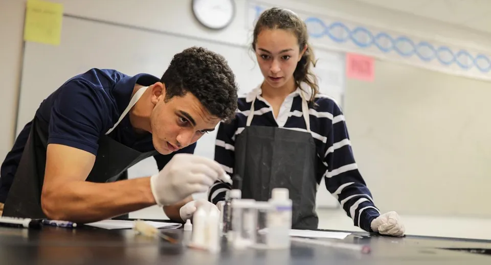 Due studenti della Saint Andrews School lavorano insieme a un tavolo nel laboratorio.