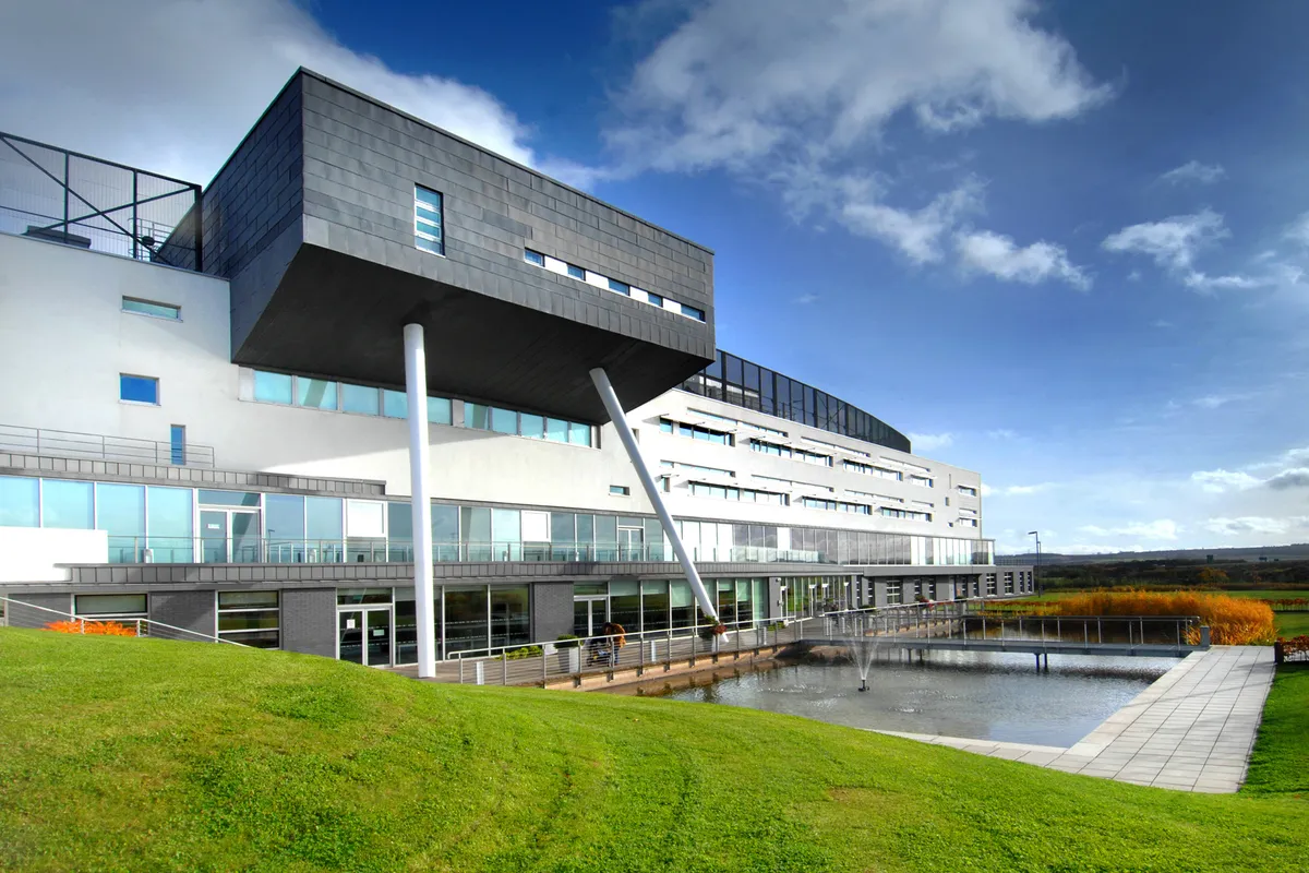Edificio moderno della Queen Margaret University con il volume nero a sbalzo e il prato verde davanti