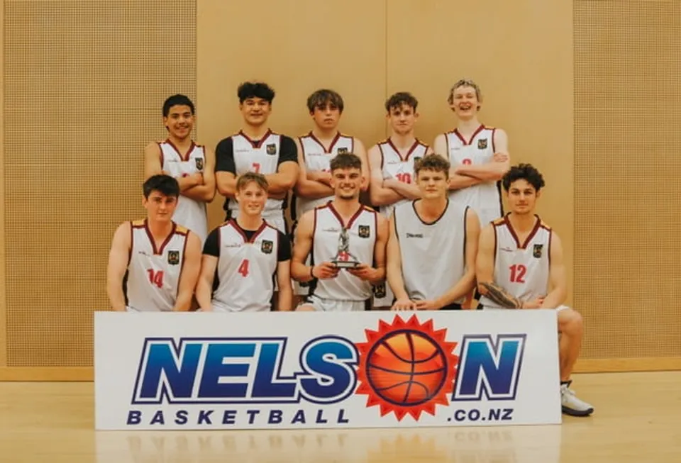Un gruppo di studenti del Garin College posa nella palestra con un trofeo di pallacanestro.