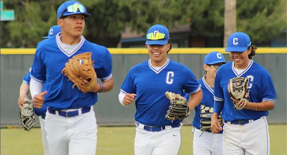 Un gruppo di studenti che giocano a baseball in divisa blu si trova sul campo da baseball del Chino Valley Unified School District.