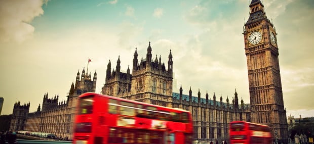 Rote Doppeldeckerbusse fahren am Westminsterpalast mit Big Ben vorbei