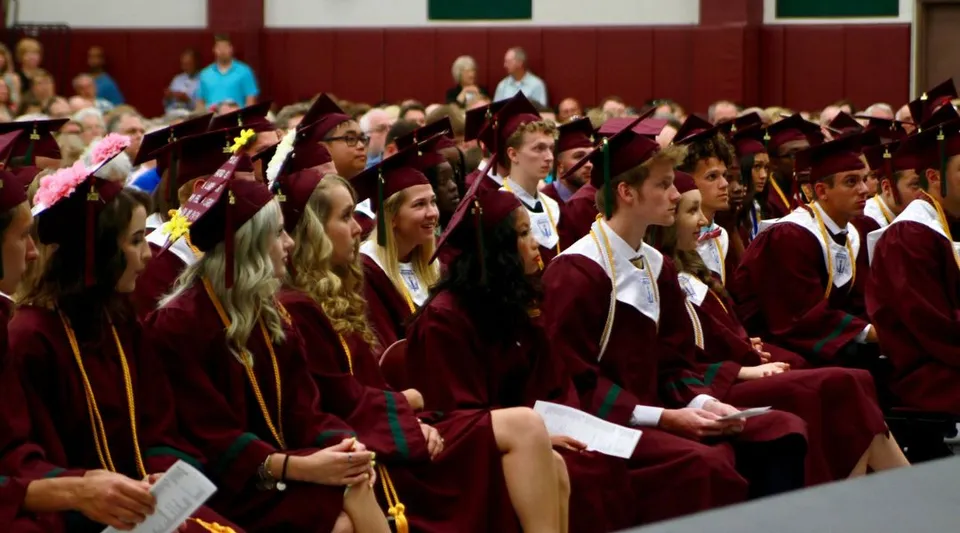 I diplomati della Covenant Christian High School indossano le toghe per la cerimonia di diploma in un'aula magna.