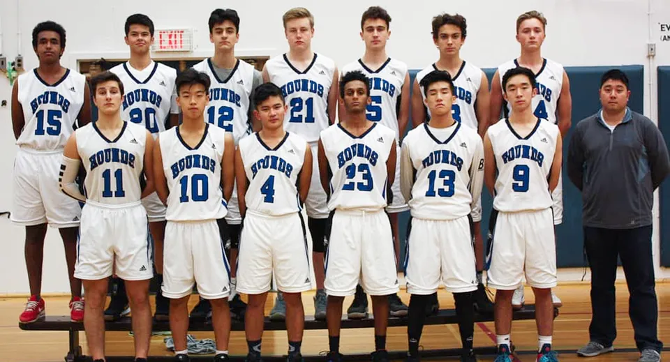 Un gruppo di studenti della Point Grey Secondary School posa in divisa da basket sul campo da gioco.