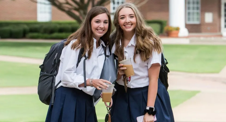 Due studentesse della The Brook Hill School sono insieme all'aperto davanti a un edificio in mattoni.