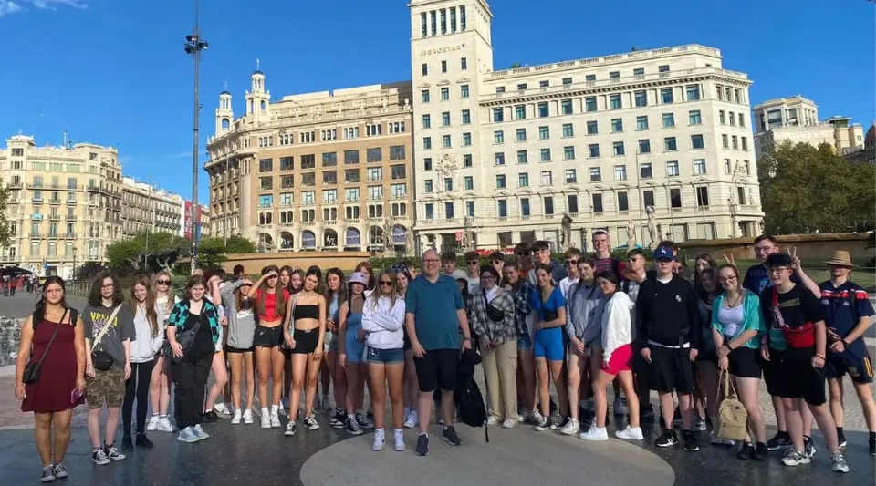 Un gruppo di studenti si trova davanti all'edificio storico del Carrignafoy Community College in città.