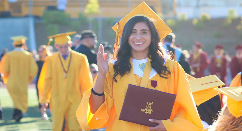 Una studentessa in toga gialla da diploma tiene in mano un diploma durante la cerimonia di diploma al Placentia-Yorba Linda Unified School District.