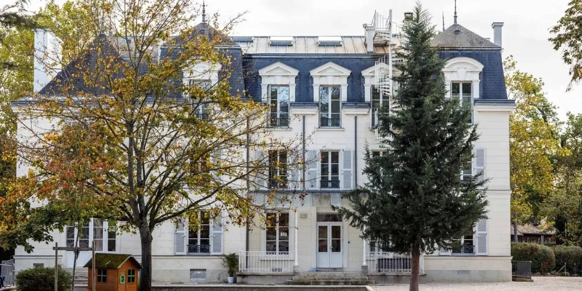 L'edificio a più piani della Ermitage International School è circondato da alberi e altri edifici.