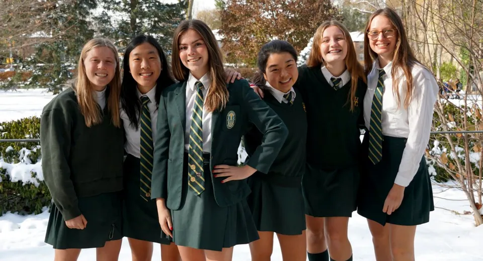 Un gruppo di studentesse in divisa scolastica si trova in un paesaggio invernale innevato nel campus dell'Havergal College.