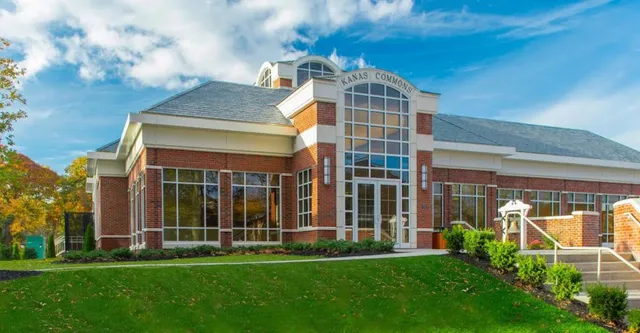 L'edificio moderno a più piani di The Stony Brook School con ingresso a vetrate e un prato curato.
