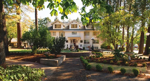 Ein viktorianisches Haus auf dem Campus der Canyonville Academy ist von üppigem Grün umgeben.