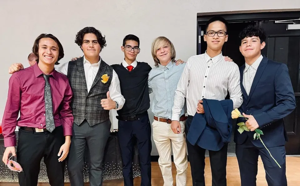 Un gruppo di sei studenti in piedi insieme in uno spazio interno della Mission Heights Preparatory High School.