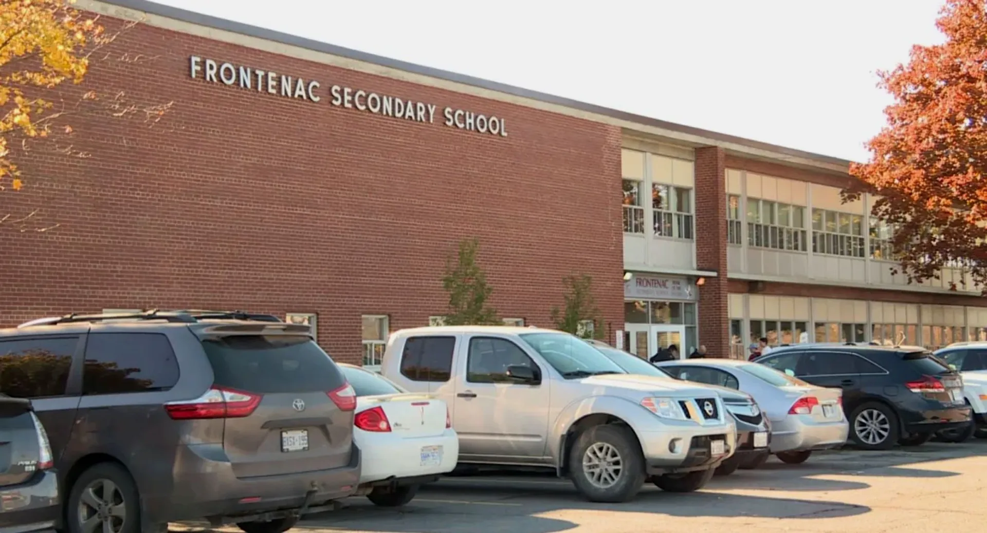 L'edificio in mattoni della Frontenac Secondary School con diversi veicoli parcheggiati in primo piano.