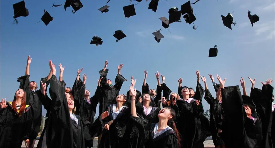 I diplomati della Nakusp Secondary School lanciano i loro tocchi nel cielo limpido.