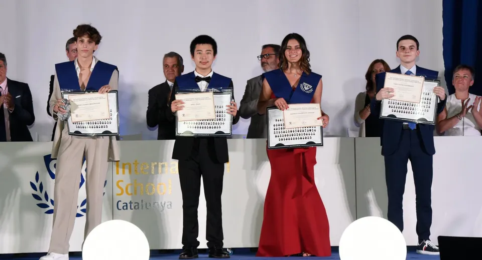 Un gruppo di studenti della SEK International School Catalunya è sul palco e tiene in mano dei certificati.