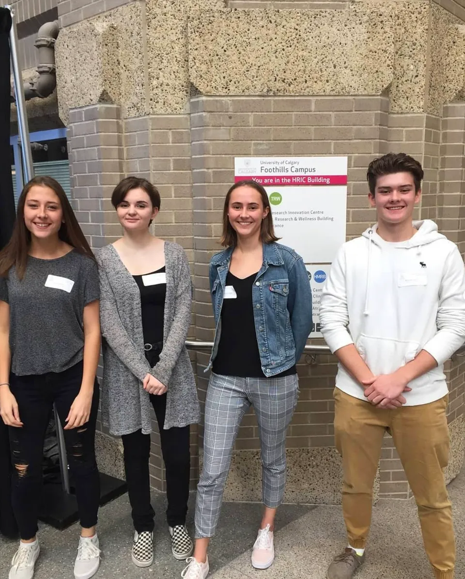 Quattro studenti si trovano davanti all'edificio con l'insegna Facilities Campus nel campus della Lord Beaverbrook High School.