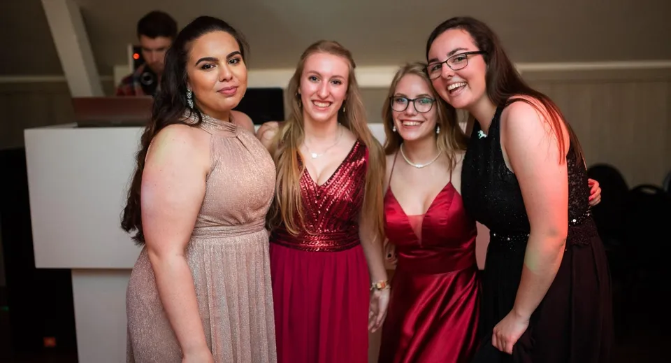Quattro studentesse della St. James’ School mettono in posa in abiti eleganti insieme durante una festa.