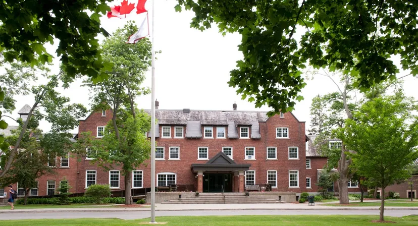 L'edificio in mattoni con un ingresso caratteristico e la bandiera canadese sul campus dell'Ashbury College.