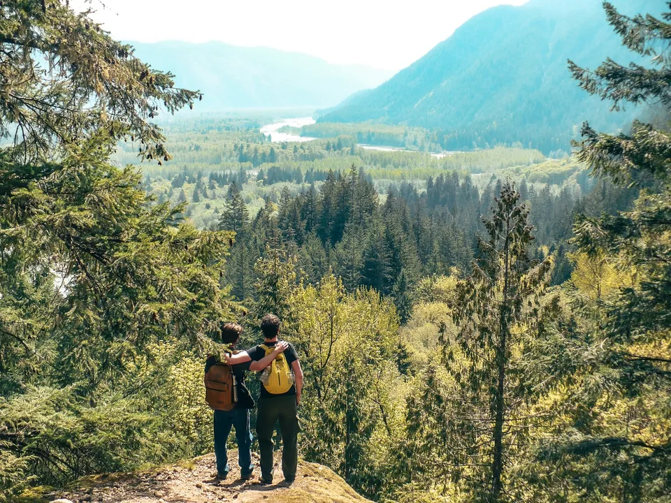 Due persone con zaini guardano da un punto panoramico una valle boscosa vicino alla Pioneer School Port Coquitlam.