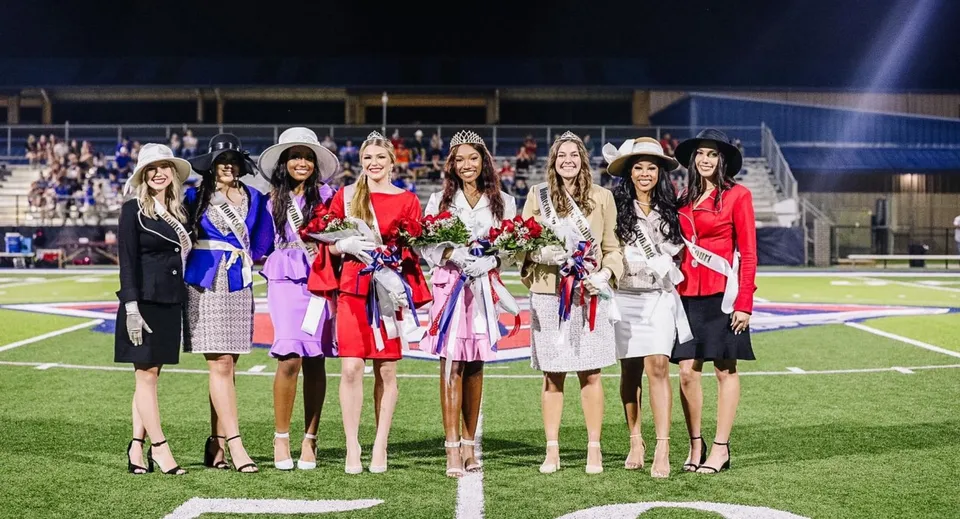 Un gruppo di studentesse della Lafayette Christian Academy si trova di notte sul campo da gioco e tiene mazzi di fiori durante una festa.