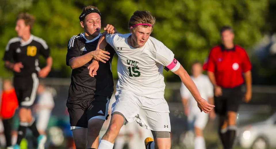 Due studenti della Western Michigan Christian School giocano l'uno contro l'altro sul campo da calcio.