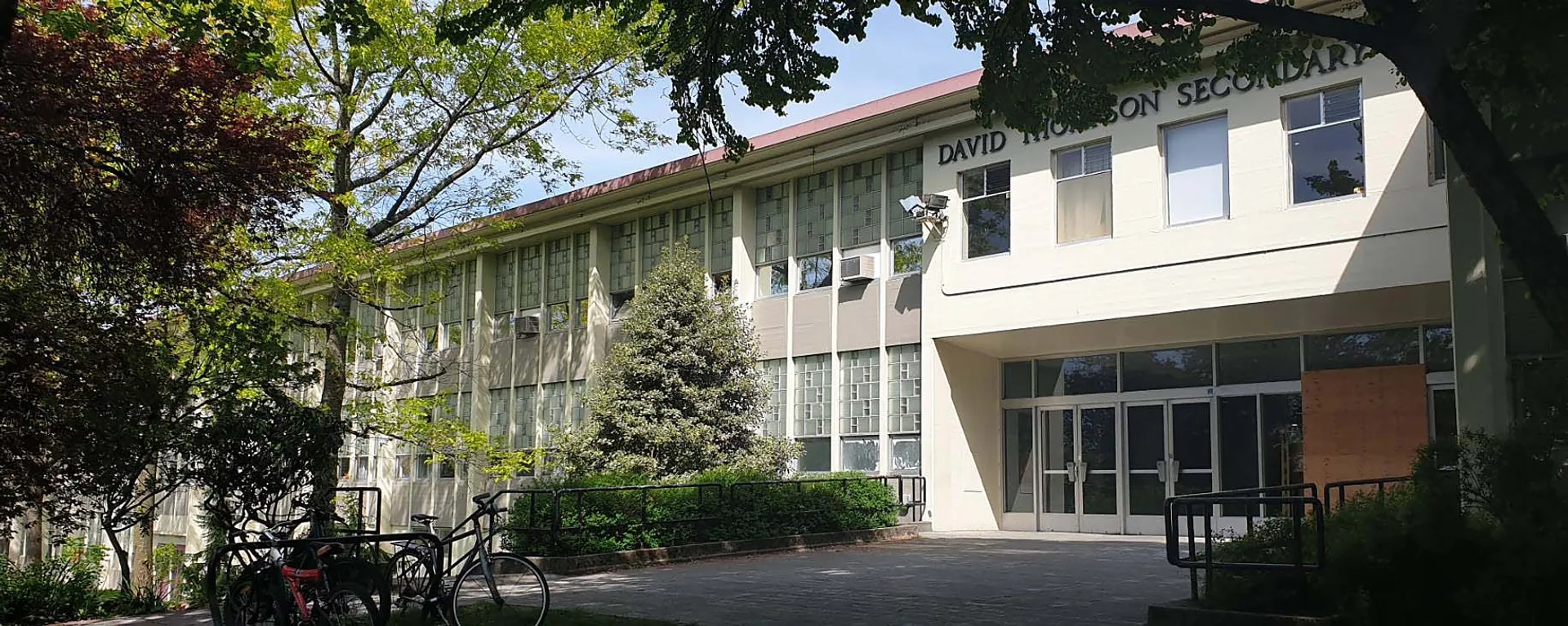 Edificio a più piani con ampie finestre e alberi nel campus della David Thompson Secondary School a Vancouver.