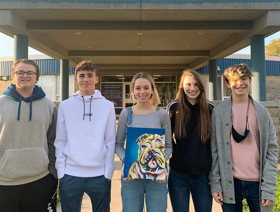 Un gruppo di cinque studenti sta in piedi insieme davanti a un edificio nel campus della Centerville Senior High School.