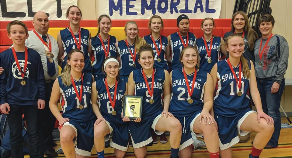La squadra di pallacanestro della Forest Lawn High School posa insieme al suo trofeo dopo una vittoria.