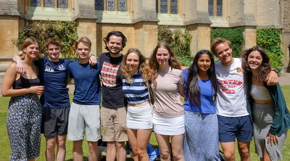 Un gruppo di studenti si trova davanti a un edificio dall'architettura decorata nel campus dell'Exeter College.