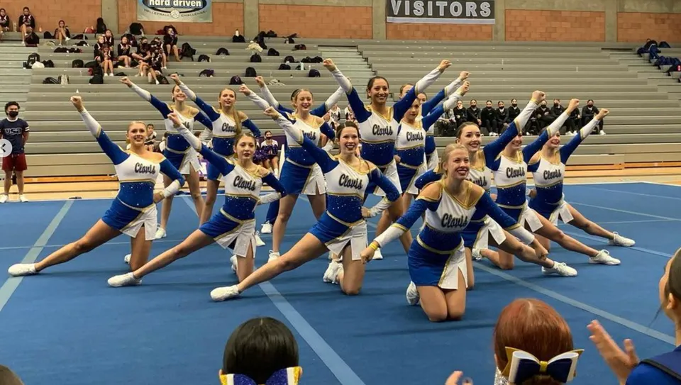 Un gruppo di cheerleader della Clovis High School esegue una coreografia sincronizzata in palestra.