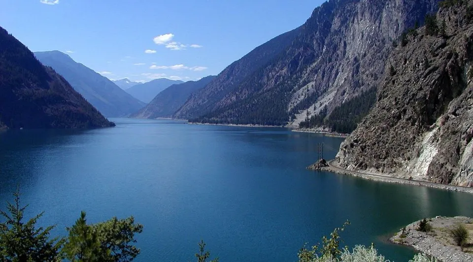 Un ampio lago blu circondato da ripide montagne nei dintorni della Leo Burke Academy.