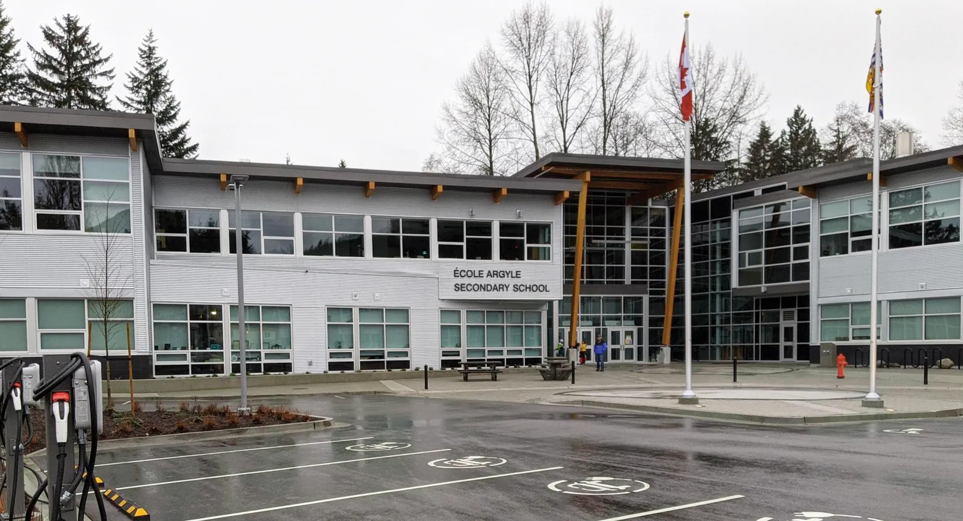 L'edificio moderno a più piani della Argyle Secondary School è circondato da alberi e da un parcheggio pavimentato.