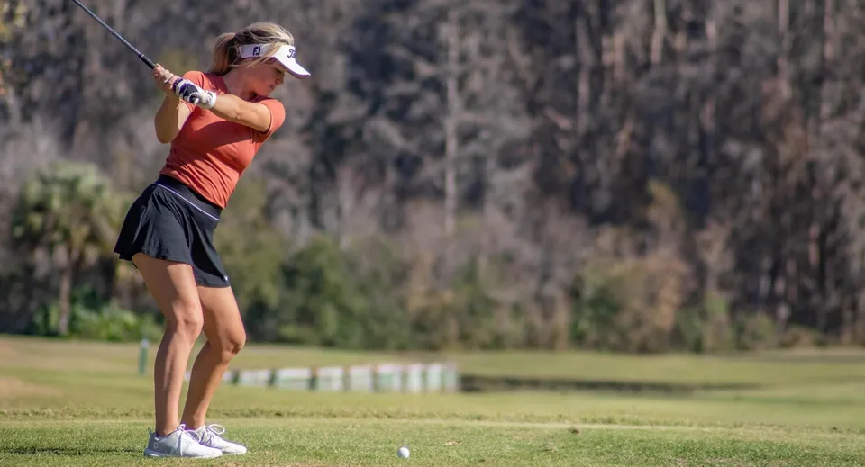 Una studentessa della Saddlebrook Preparatory School si prepara a colpire una pallina su un campo da golf.